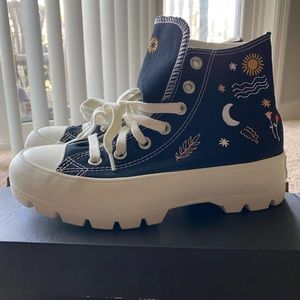 Black converse high tops with various embroidered designs, platform.